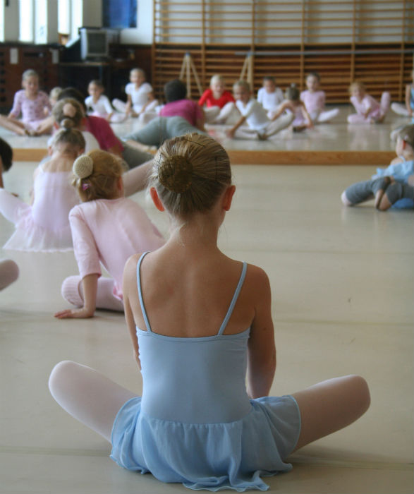 Balletelever sidder på gulvet
